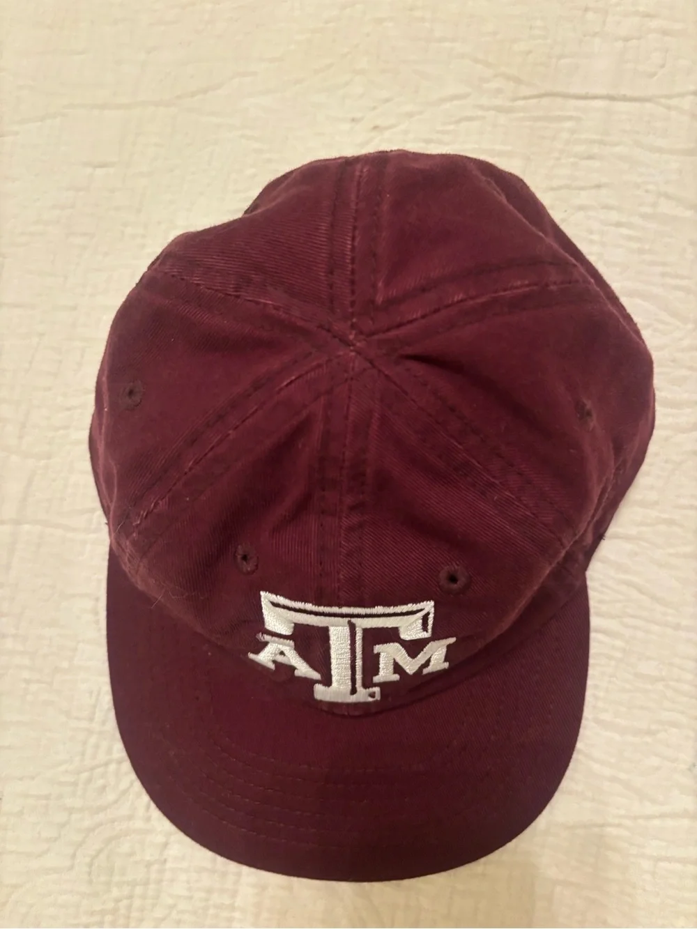 A&M baby baseball cap, elastic back w/ white embroidered A&M Logo & Lil’Aggie